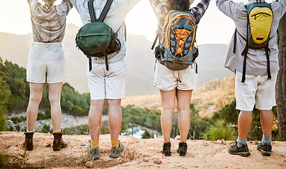 Image showing Fitness group celebrating on hike in nature, enjoying hiking view on a mountain on a wellness getaway vacation together. Back of friends walking on weekend and relaxing on summer holiday.