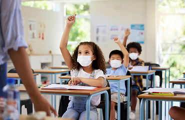 Image showing Covid, education and learning of eager, smart and clever children raising hands and wearing masks in a classroom. Teacher or educator asking questions for knowledge test at kids school in a pandemic.