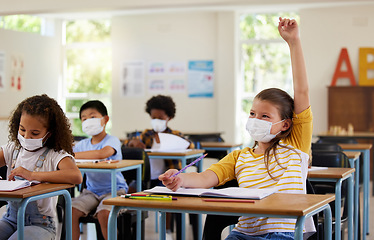 Image showing Wearing face mask to protect from covid while learning in class, answering education question and studying with students in a classroom. Girl sitting at a desk and raising hand during a pandemic