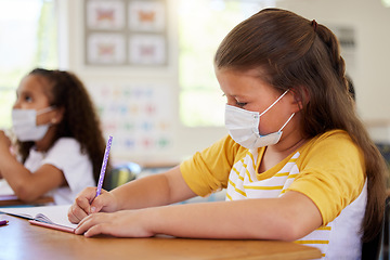 Image showing School girls in classroom, covid education lockdown and social distance. Smart students creative drawing and writing at desks learning, wearing masks due to coronavirus disease regulations.