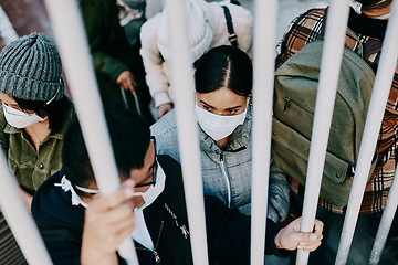 Image showing Covid travel ban, lockdown or border control to prevent spread of pandemic virus, contagious disease or illness. Travelers in masks facing quarantine, abuse and discrimination behind locked gate