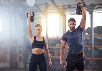 Image showing Fitness couple doing a kettlebell workout, exercise or training in a gym. Fit sports people, woman or man with a strong grip, exercising using gyming equipment to build muscles and forearm strength