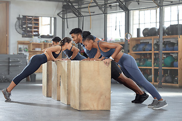 Image showing Group training, incline push up and bodyweight exercise, workout and fitness in a gym class with plyometric jump boxes. Sporty, strong and active people with endurance, energy and wellness challenge