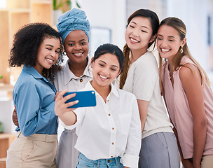 Image showing Diverse fun business friends taking selfies on a phone together in an office. Happy and beautiful colleagues or friends smiling for photos and posing as an ambitious team in a startup agency