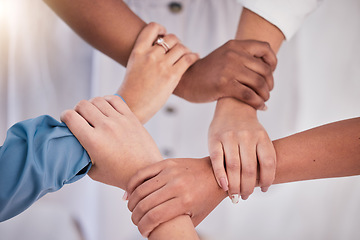 Image showing Diverse colleagues hands holding wrists from above in support of unity, loyalty and teamwork in the workplace. Professional business synergy, trust and collaboration working towards strategy goal.