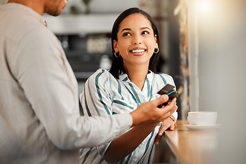 Image showing Customer paying using contactless credit card, standing by cafe or restaurant bar counter. Smiling woman make cashless payment for coffee bill with wireless NFC tag reader technology POS machine.