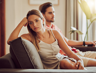 Image showing Unhappy, sad and annoyed couple after a fight and are angry at each other while sitting on a couch at home. A woman is stressed, upset and frustrated by her boyfriend after an argument