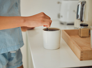 Image showing Making fresh, hot morning coffee indoors on a kitchen counter to start the day. Hand closeup of preparing a warm beverage and drink inside with a female standing in pajamas at home