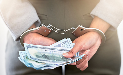 Image showing . Handcuffs, dollars and a business woman arrested for theft at work. Money, crime and punishment for fraud with female lawyer in prison. Cash, restraints and a criminal trying to bribe an officer.