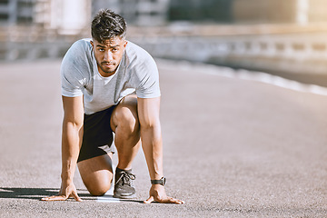 Image showing Runner in starting position for race, run or cardio for healthy exercise, workout or fitness in urban city. Active, fit and serious male sports athlete ready for training, running fast and sprint