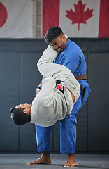 Image showing . Mma, training and fighting with a student and teacher exercising during a self defense workout in a gym or fight studio. Combat sport with a fighter and his opponent in gi or uniform in a match.