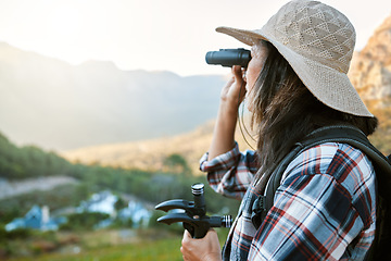 Image showing Hiking, exploration and mountain adventure with binoculars, trekking pole and walking aid in a remote landscape with view. Mature woman, hiker and tourist watching birdlife or wildlife in eco nature