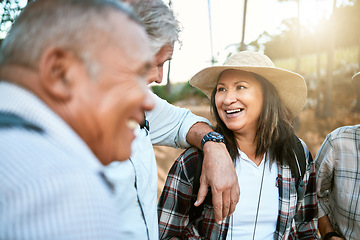 Image showing Happy senior woman in nature with friends while taking an outdoor walk in spring. Smiling mature woman having a conversation with a man outside. Old smiling lady having fun while hiking with aged men