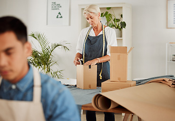 Image showing . Fashion, design and style with a tailor, seamstress or creative designer packing boxes for shipment and delivery. Female stylist preparing a box to complete an order in her studio or workshop.