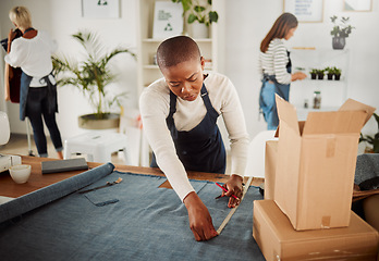 Image showing . Fashion designer, tailor and creative entrepreneur measuring material and textile for fashionable and trendy clothing in her startup business. Using a tape measure to trim or cut fabric for design.