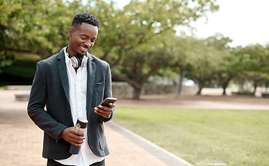 Image showing Young, cool smiling businessman on a phone having a walk in the park outside in nature. Happy man texting, chatting or reading messages on a smartphone outdoors on a break from work, over copy space.