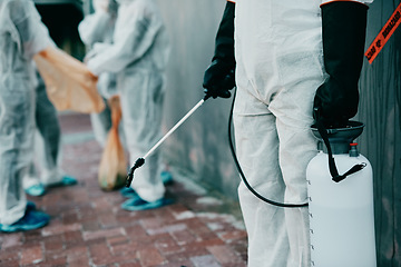 Image showing Healthcare workers, cleaning and working to prevent an outbreak of covid. Medical worker in sterile uniform, holding disinfectant and sterilizing. People in protective suits disinfecting the area.