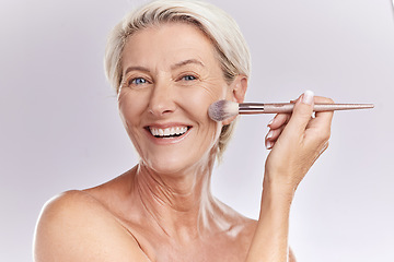 Image showing Beauty, makeup and cosmetics of senior woman with a make up brush applying foundation, concealer or cosmetic product with a smile portrait. Happy blonde lady showing skincare for reducing wrinkles