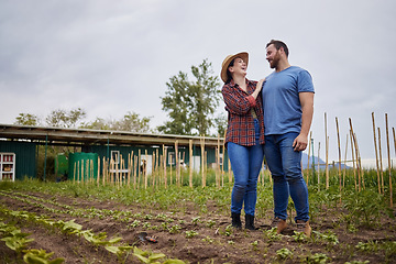 Image showing Farmer couple happy about growing vegetable crops or plants in their organic or sustainable farm or garden. Affectionate nature activists enjoying the outdoors and having fun together