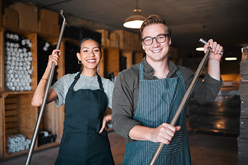 Image showing Wine making workers with press tool or equipment inside a cellar, winery or distillery warehouse with bulk quality alcohol. Woman, man or sommelier people with smile portrait for industry background