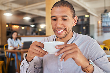 Image showing Man enjoying a cup of coffee, while smiling and sitting at a cafe relaxing. Businessman drinking tea or caffeine at restaurant. Relaxed and happy male holding a mug or beverage in a coffee shop