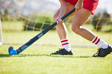 Image showing Field hockey, sports and training with a player hitting a ball with a stick and practicing for a match or sport event. Closeup of a sporty athlete being active, healthy and fit while running outside