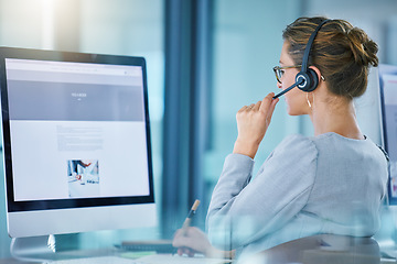 Image showing CRM call center agent talking using wireless headset, consulting client online, giving feedback, working on computer. Helpdesk hotline support operator browsing internet doing customer service work.