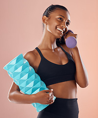 Image showing Fitness, active and healthy woman holding a dumbell, foam roller and smile after sports training against studio background. Happy fit lady feel slim, happy and cheerful after gym, workout or exercise