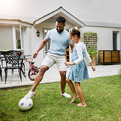 Image showing Father and daughter bonding, playing with soccer ball in backyard at home, smiling and having fun. Happy parent being playful and enjoying family time with his child. Guy being active with his kid