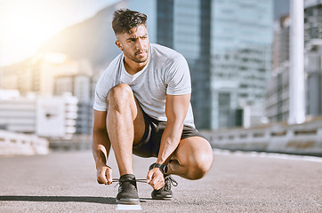 Image showing Tie shoes, fit and healthy man ready for a run, exercise and workout or training routine in urban city. Active athletic male living a health, wellness and body or weight watching fitness lifestyle