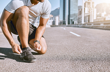 Image showing Tie shoes, wellness and fitness male runner ready for run, exercise and workout or cardio training. Healthy, fit and active male jogger preparing for jogging, exercising or physical activity