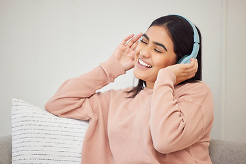 Image showing Headphones, listening to music and dancing to fun, happy radio songs while relaxing on home living room sofa. Smiling, cheerful and singing woman having fun and enjoying podcast or dance media sound