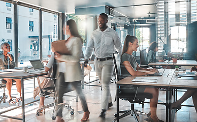 Image showing Busy office with a productive team of employees working hard and fast to complete tasks and projects. Colleagues, coworkers or business people in a modern workplace being creative