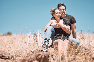 Image showing Carefree, smiling and relaxed couple bonding, having fun and looking at the view while sitting on the grass in a nature park together. Loving, caring and romantic boyfriend and girlfriend hugging