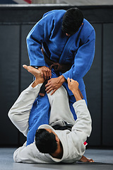 Image showing Karate, fitness and exercise of a student training with a coach and learning in a contact sport. Man with personal trainer in martial arts sports fight for safety, wellness and health in a gym.