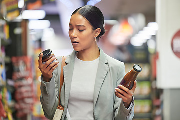 Image showing Shopping, retail and customer in a store or supermarket, reading product labels of choice to decide or compare sauce bottles. Consumerism, spending and shopping for food, groceries and a sale offer