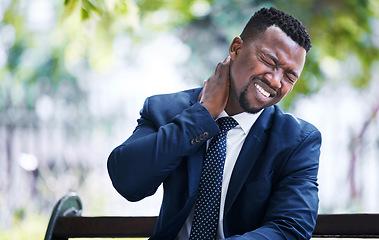 Image showing Stress, burnout or pain and a business man with an neck injury in the city. Corporate worker in need of medical aid or emergency care after an accident sitting on a bench, overworked with a headache