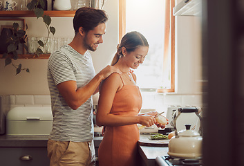 Image showing Romantic, caring and loving young couple supporting each other while preparing a meal in the kitchen. Man and woman in a happy, stressless and relaxed relationship together cooking at home.