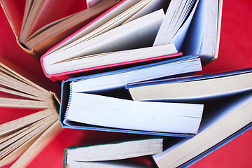 Image showing Books, education and learning for knowledge, scholarship or research with red background. Studying, reading and college lifestyle with art or library book, fiction and literature in a creative studio