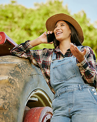 Image showing Agriculture, sustainability and farmer talking on phone while working on a farm with a tractor. Wellness, health and agro woman networking with a mobile while standing on a field in the countryside.