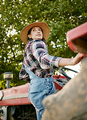 Image showing Woman agriculture worker or farmer on tractor working farm during harvest time. Sustainability farming in the countryside. Serious girl farming in a field, fresh produce for farmers market