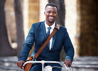 Image showing Portrait of a happy businessman on bike or bicycle on his morning travel into work in the city. Employee,, entrepreneur or worker on the ride with decrease his carbon footprint with a suite and smile