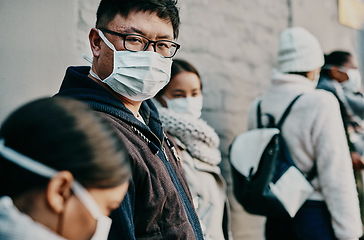 Image showing Compliance, safety and covid travel restrictions with a group waiting in line to get a vaccine or booster shot. Corona face mask requirement in a crowd with diverse people waiting in to go abroad