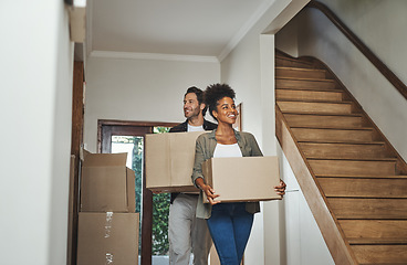 Image showing Excited, happy and young couple moving into a new home together while carrying and packing household boxes. Smiling, positive and cheerful husband and wife in a lovely modern real estate property