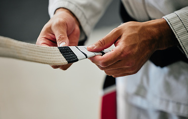 Image showing Fitness, training and karate teacher hands prepare uniform for new student at a center or dojo. Martial arts sensei getting ready to lead a lesson on self defense, speed and physical endurance.