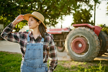 Image showing Farm, tractor and a woman in a hat in nature or field farming food, fruits and vegetables. Agriculture and natural environment with farmer in the countryside in the summer sun working on harvest