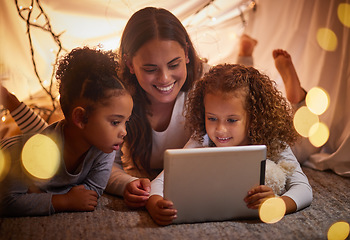 Image showing Home tent mother and kids on tablet watch movie or online children entertainment movies at night at house. Happy smile mom or woman and young girl youth family watching or playing fun internet games