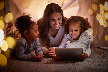 Image showing Mother and children live streaming on an app using a tablet in a tent camping at home at night. Happy mom and kids watching online content or playing games with house wifi in the dark or evening
