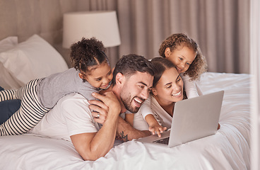 Image showing Happy family streaming movies on laptop in bedroom for online entertainment to relax during the night at home. Smile, mother and father with girls, children or kids watching tv via internet together