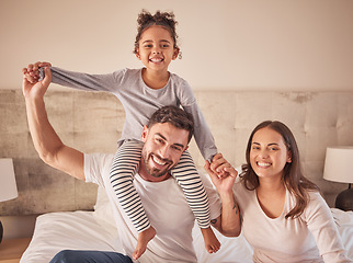 Image showing Family, mother and father with happy girl sitting in bedroom together spending quality time relaxing at home. Smile, parents and freedom with young child on dads shoulders next to mom in portrait